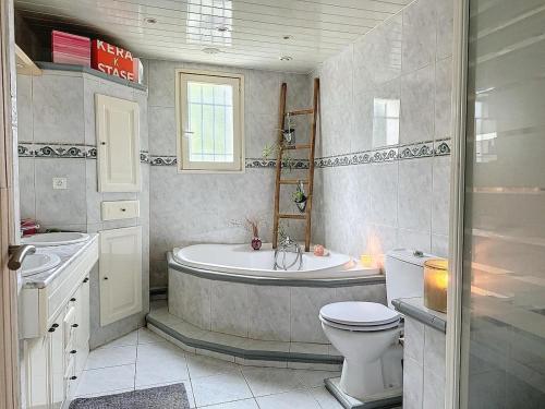 une salle de bain avec une baignoire, des toilettes et un lavabo dans l'établissement Spacieuse villa Les Alizées, à Montélimar