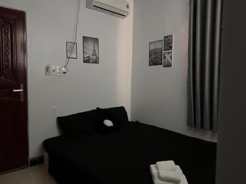a bedroom with a black bed in a room at Jun house - Bến cảng rạch giá in Rach Gia