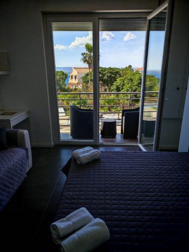 a room with a balcony with a view of the ocean at Villa Plemmirio Reserve in Plemmirio