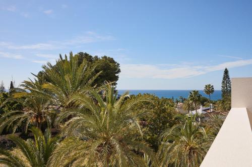 a view of the ocean from a resort with palm trees at Kimpton Los Monteros Marbella by IHG in Marbella