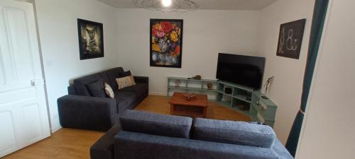 un salon avec un canapé et une télévision dans l'établissement Villa du homard bleu, à Donville-les-Bains