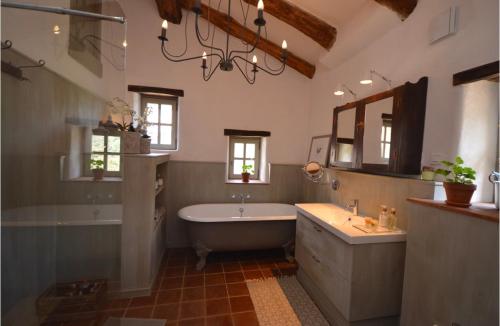 La salle de bains est pourvue d'une baignoire, d'un lavabo, d'une baignoire et d'un miroir. dans l'établissement Le Vaquier, à Soudorgues