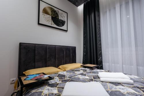 a bedroom with a large bed with a black headboard at MANIROSI 19 PALIC - Apartment in Palić