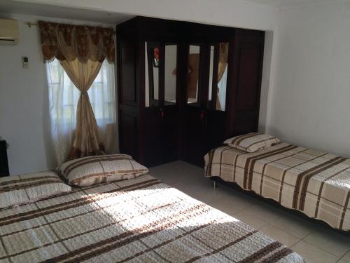 a bedroom with two beds and a window at Posada Miss Portia in Providencia