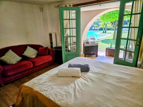 - une chambre avec un grand lit et un canapé rouge dans l'établissement Villa, Villefranche-sur-mer, Pool, Tennis Court,, à Villefranche-sur-Mer