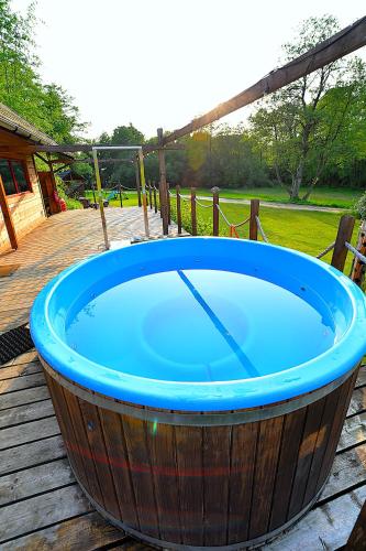 a large wooden tub sitting on a wooden deck at Wytwórnia Ciszy i Spokoju Apartamenty Wojtokiemie in Puńsk