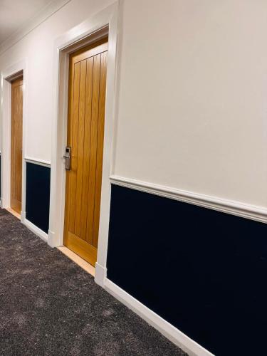 a hallway with two doors and a wall at Thomas Arms Hotel in Llanelli