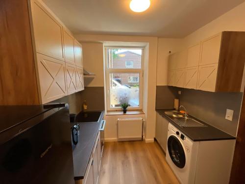 a kitchen with a washing machine and a window at Zentrale Unterkunft in Neumünster in Neumünster