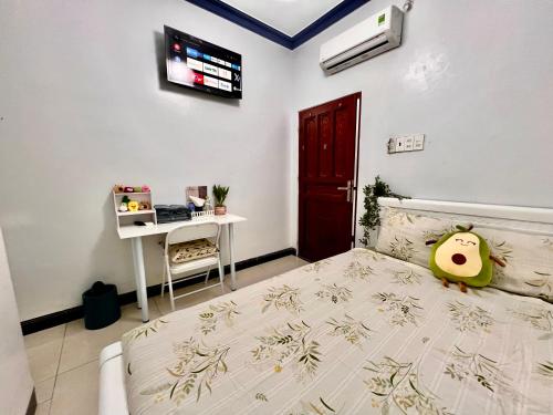 a bedroom with a bed and a desk in it at Jun house - Bến cảng rạch giá in Rach Gia