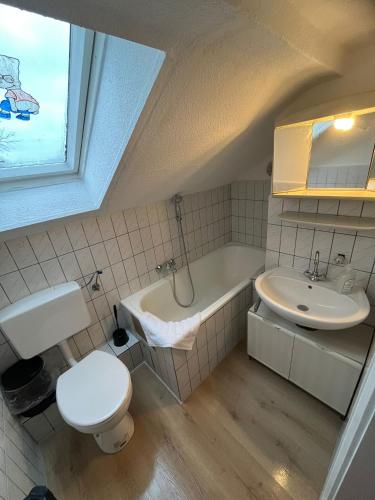 a bathroom with a toilet a sink and a bath tub at Zentrale Unterkunft in Neumünster in Neumünster