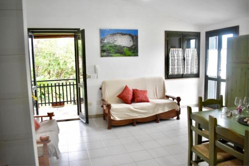 a living room with a couch and a balcony at Villa giulia in Domus de Maria