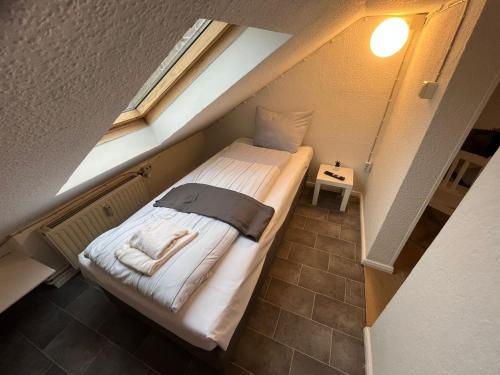a small bed in a small room with a window at Zentrale Unterkunft in Neumünster in Neumünster