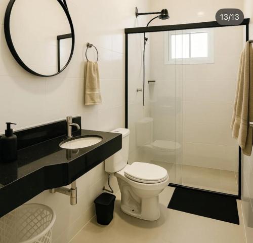 a bathroom with a toilet and a sink and a mirror at Condomínio Diamond - Novo - Centro in Corumbá