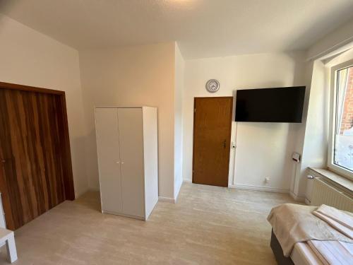 an empty room with a television and a bedroom at Zentrale Unterkunft in Neumünster in Neumünster