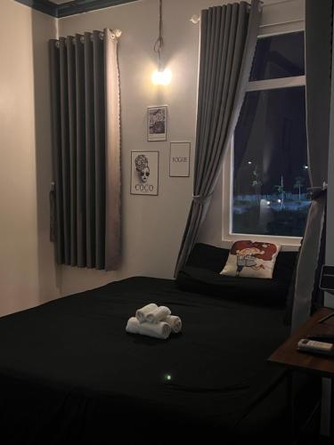 a room with a bed with a window and a towel at Jun house - Bến cảng rạch giá in Rach Gia