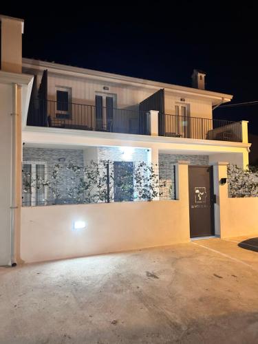 a large white building with a balcony at night at Affittacamere Su Montecitoriu in Tortolì