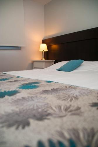a large white bed with a blue pillow on it at Links Apart Hotel in Río Grande