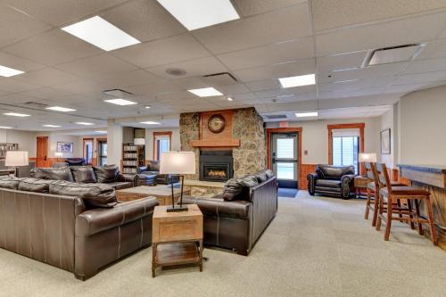 a large living room with leather furniture and a fireplace at Wedgewood Lodge in Breckenridge