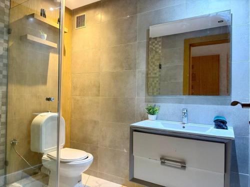 a bathroom with a toilet and a sink and a mirror at Modern Duplex in Downtown with Netflix & IPTV in Kenitra