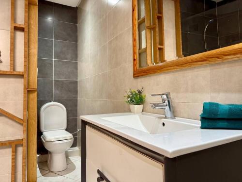 a bathroom with a sink and a toilet and a mirror at Modern Duplex in Downtown with Netflix & IPTV in Kenitra