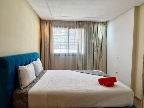 a bedroom with a bed with a red object on it at Modern Duplex in Downtown with Netflix & IPTV in Kenitra