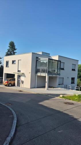 a white building with a balcony on the side of a street at Apartments Seibel Doppel-Zweibettzimmer mit Bad in Reutlingen