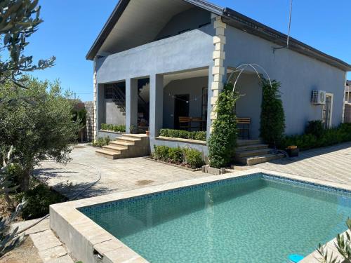 una casa con piscina delante de una casa en Home Turkan, en Türkan