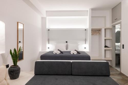 a bedroom with a large bed and a couch at Nysa Kea - A Cycladic House in Korissia