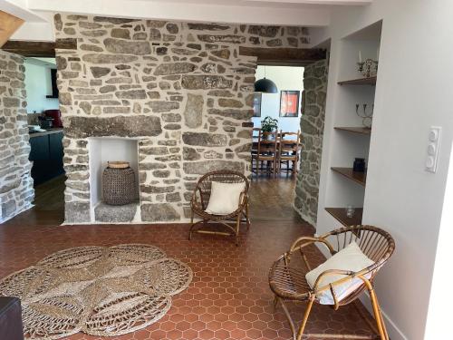 - un salon avec une cheminée en pierre et des chaises dans l'établissement Domaine de Keryouen, à Trégunc