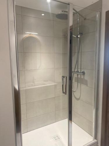 une douche avec une porte vitrée dans une salle de bain dans l'établissement Domaine de Keryouen, à Trégunc