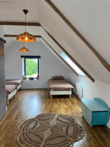 Cette chambre mansardée comprend 2 lits et un tapis. dans l'établissement Domaine de Keryouen, à Trégunc