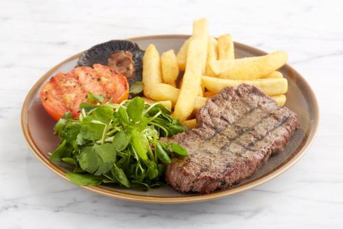 a plate of food with steak and french fries at Holiday Inn Ipswich by IHG in Ipswich