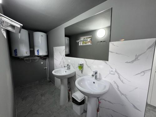 biała łazienka z umywalką i lustrem w obiekcie Hostel 53 w mieście Biszkek
