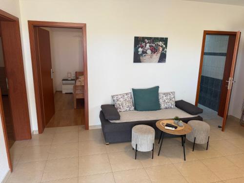 a living room with a couch and a table at Apartman Kraljević Vir 2 in Vir