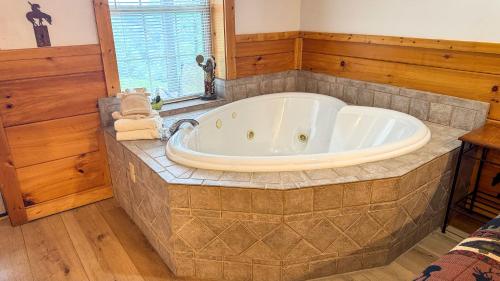 a large tub in a bathroom with wooden walls at A Painted Pony in Sevierville