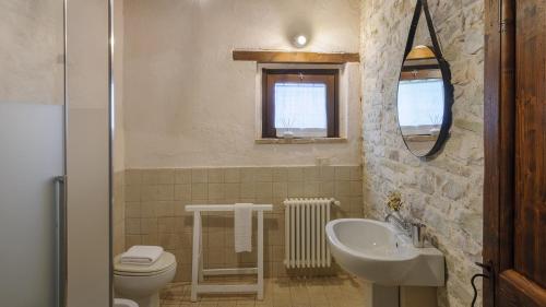 a bathroom with a sink toilet and a mirror at Checello 12 by Marche Holiday Villas in Cagli