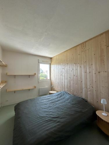 une chambre avec un lit et une fenêtre dans l'établissement Vacances a Biscarrosse entre lacs, ocean et confort, à Biscarrosse