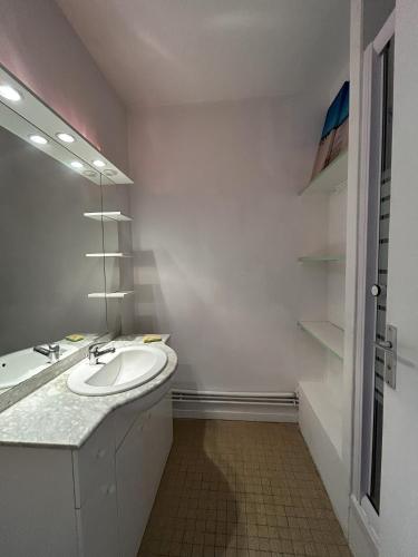 une salle de bain avec un lavabo et un miroir dans l'établissement Vacances a Biscarrosse entre lacs, ocean et confort, à Biscarrosse