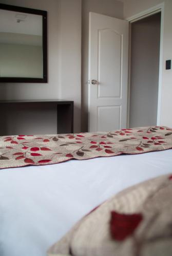 a bedroom with a bed with a flower pattern on it at Links Apart Hotel in Río Grande