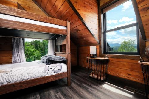a bedroom with a bed and a window in a cabin at Saving Grace Where the Mountains Save the Day in Pigeon Forge