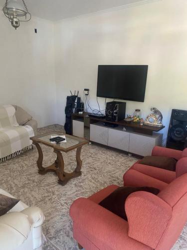 a living room with red furniture and a flat screen tv at Casa Residencial, sobrado in Serra Negra