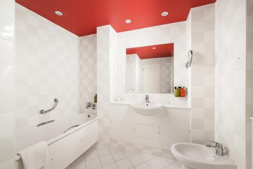 a bathroom with a sink and a tub and a toilet at Holiday Inn Leeds Brighouse by IHG in Brighouse