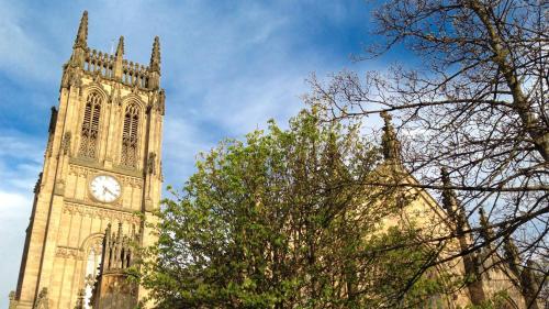 a tall clock tower with a tree in front of it at Holiday Inn Leeds Brighouse by IHG in Brighouse