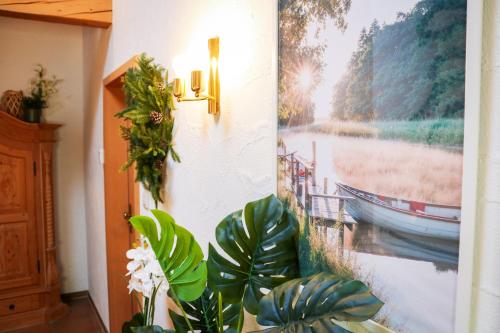 a hallway with plants and a picture on the wall at House of Happiness by apartmentglück in Schluchsee