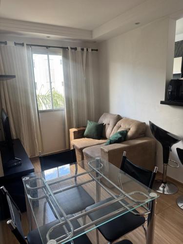 a living room with a couch and a glass table at Apartamento perto do Campolim in Votorantim