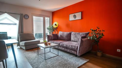 a living room with a couch and orange wall at Wohnbude Hauptbahnhof in Vienna