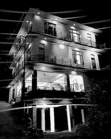 a black and white photo of a building at night at Sarjeevan Guest House in Dharmsala