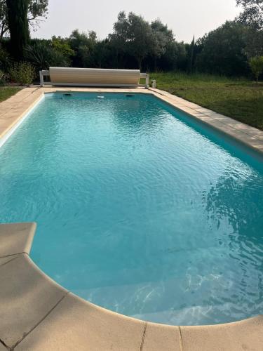 une piscine avec de l'eau bleue dans une cour dans l'établissement Charmant petit Mazet au cœur d'un magnifique jardin et d'une grande piscine à Uzès, à Uzès