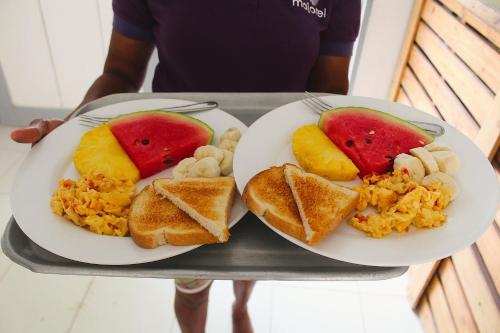 a tray with two plates of food with fruit on it at Casa Bambudas in Rincón