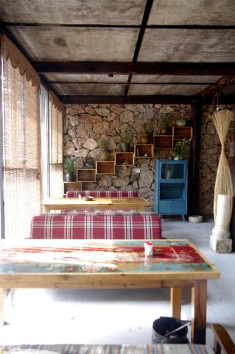 a room with two tables and a stone wall at 张家界天门山伴田居民宿 in Zhangjiajie
